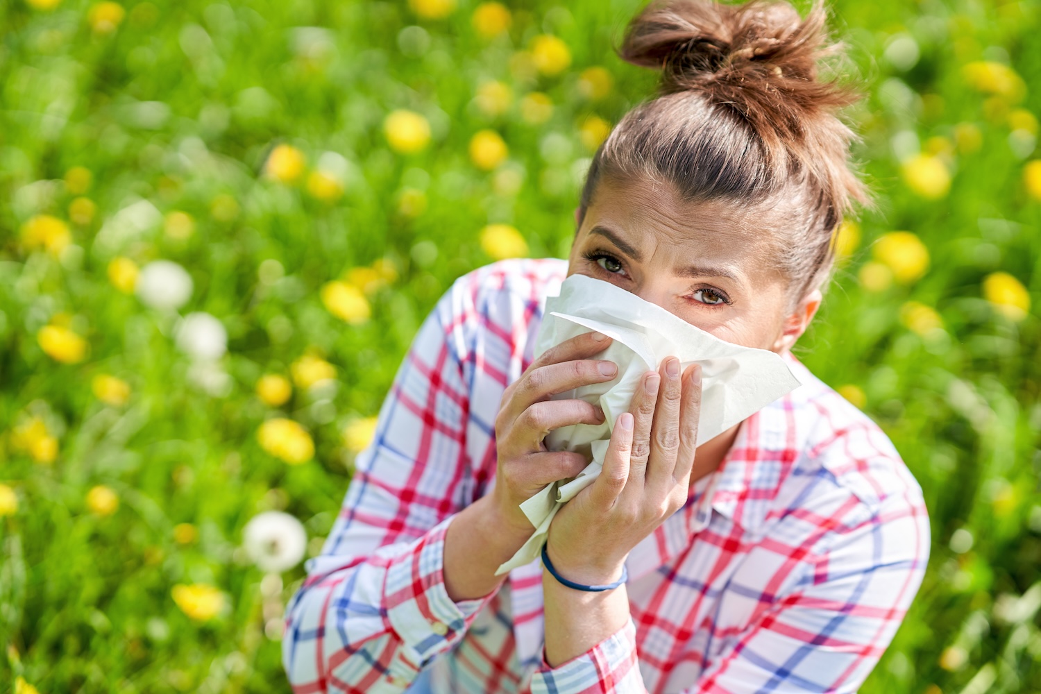 Young woman having allergic symptoms with tissue. High quality photo